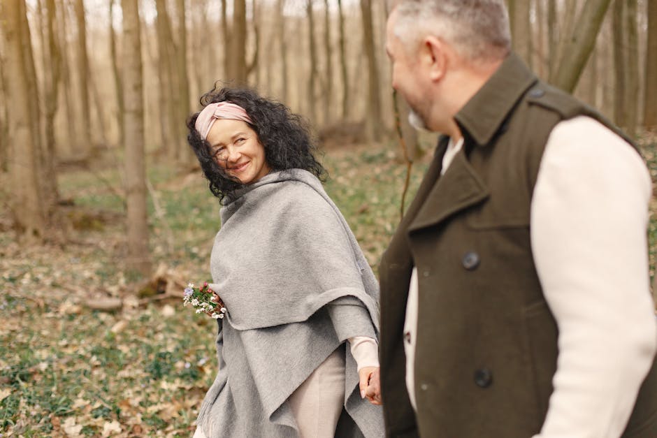 A joyful couple walking hand in hand through a peaceful forest, enjoying nature.