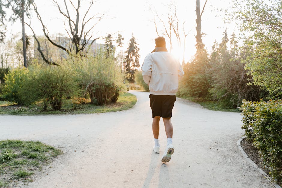 A man jogging in a park, enjoying a sunny morning workout.