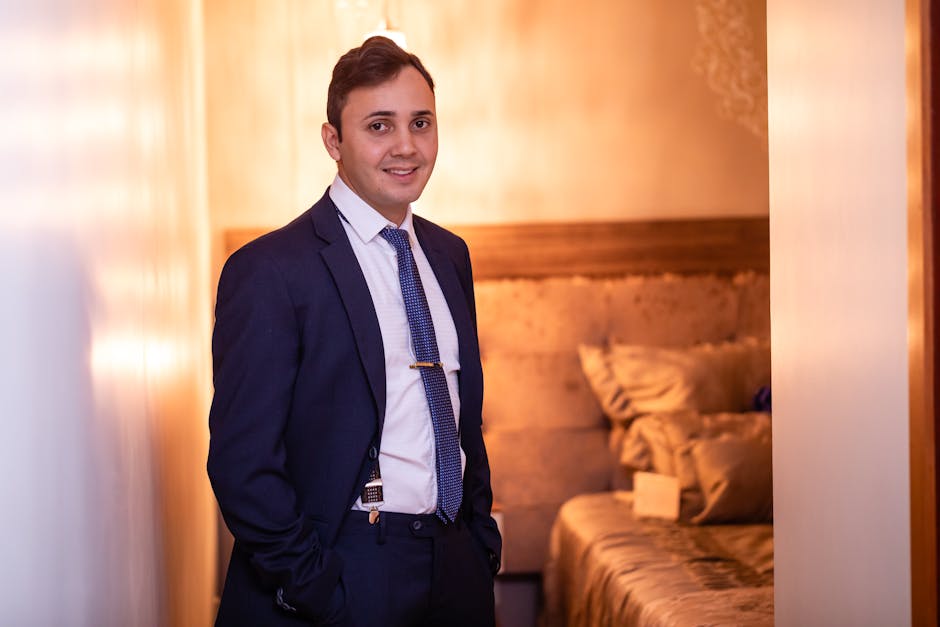 Confident Caucasian man in a blue suit smiling warmly indoors, embodying professionalism.