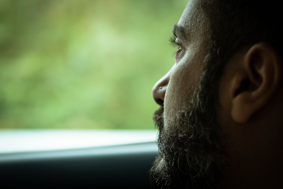 A contemplative man gazes through a window, captured in Beni M Tir, Jendouba, Tunisia.