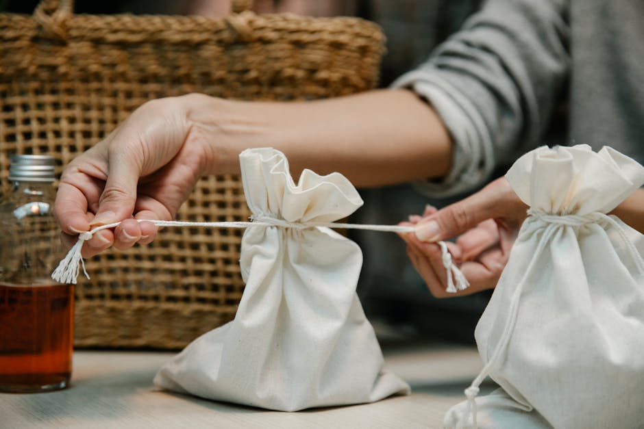 Hands tying eco-friendly cotton bags, perfect for sustainable packaging concepts.