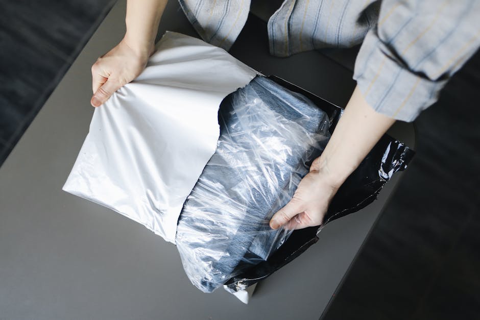 Close-up of a person unpacking a delivered parcel on a table indoors.