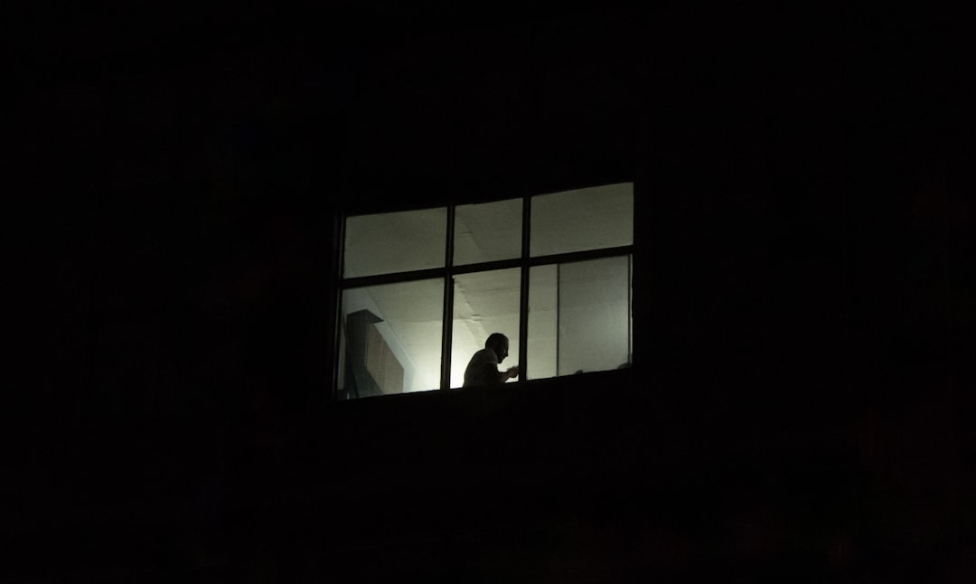 a person standing in a window at night