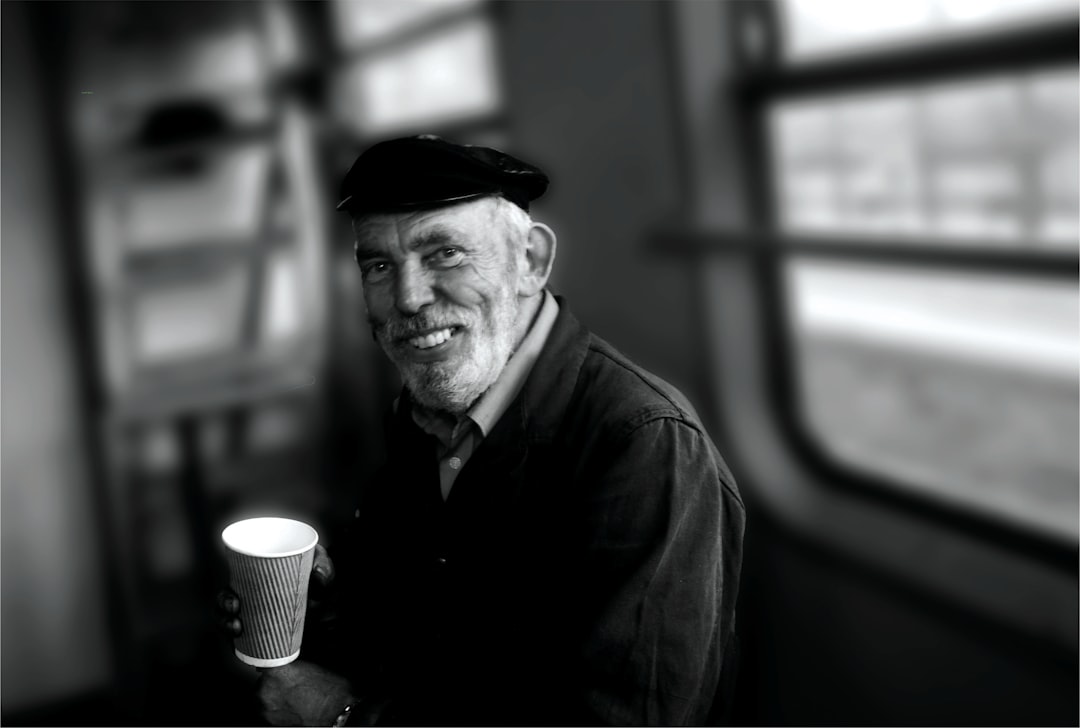 man sits while holding cup
