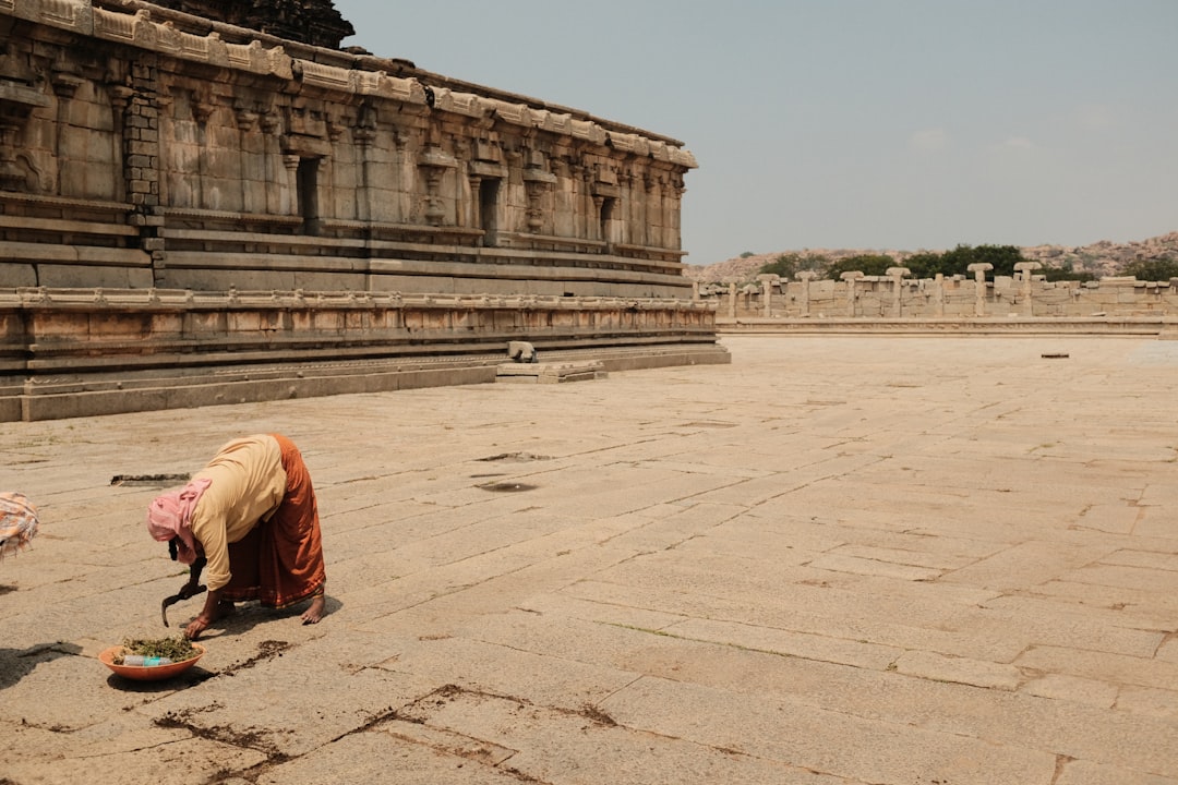 a woman kneeling down on the ground in front of a building